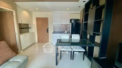Modern open-layout kitchen with sleek black appliances and dining area in stylish apartment.