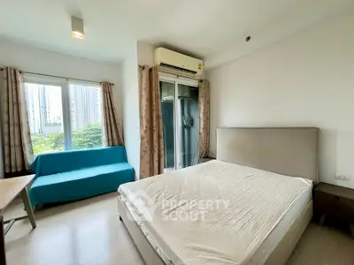Modern bedroom with large window and balcony access in urban apartment
