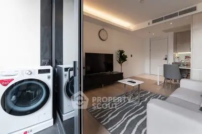 Modern living room with sleek design and in-unit washer, featuring open layout and stylish decor.