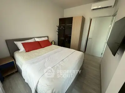 Modern bedroom with cozy bed, wardrobe, and wall-mounted TV in a stylish apartment.