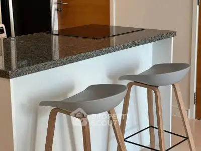 Modern kitchen with sleek granite countertop and stylish bar stools