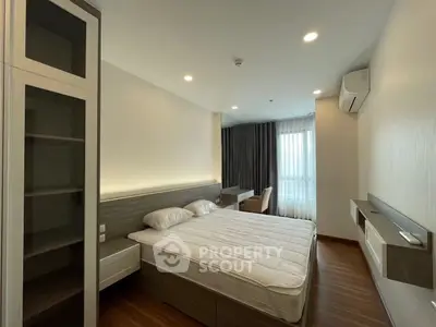 Modern bedroom with sleek design, featuring a comfortable bed, built-in wardrobe, and natural light from large window.