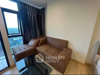 Cozy living room with brown sectional sofa and city view from large window.