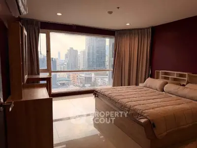 Spacious bedroom with large window offering stunning city views in modern apartment.