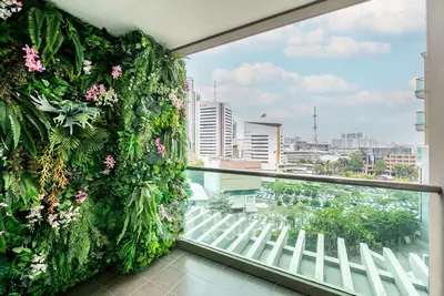 Stunning balcony with lush vertical garden and cityscape view, perfect for urban living enthusiasts.