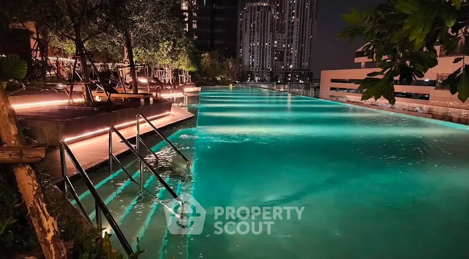 Luxurious rooftop pool with ambient lighting and city skyline view at night.