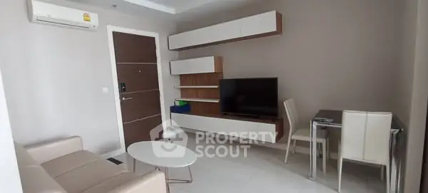 Modern living room with sleek furniture and wall-mounted TV in a cozy apartment.