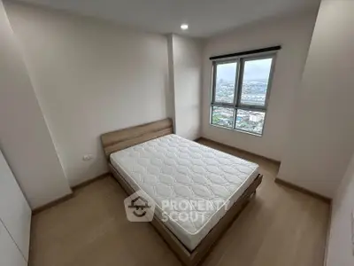 Spacious bedroom with large window offering stunning city views, featuring a comfortable bed and modern design.