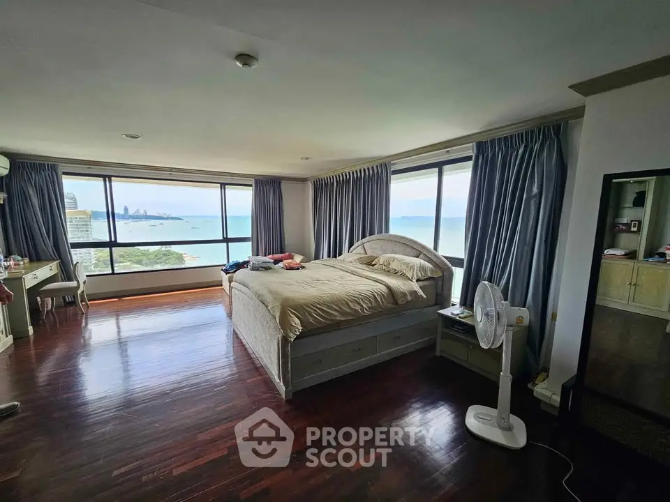 Spacious bedroom with stunning ocean view and elegant hardwood floors.