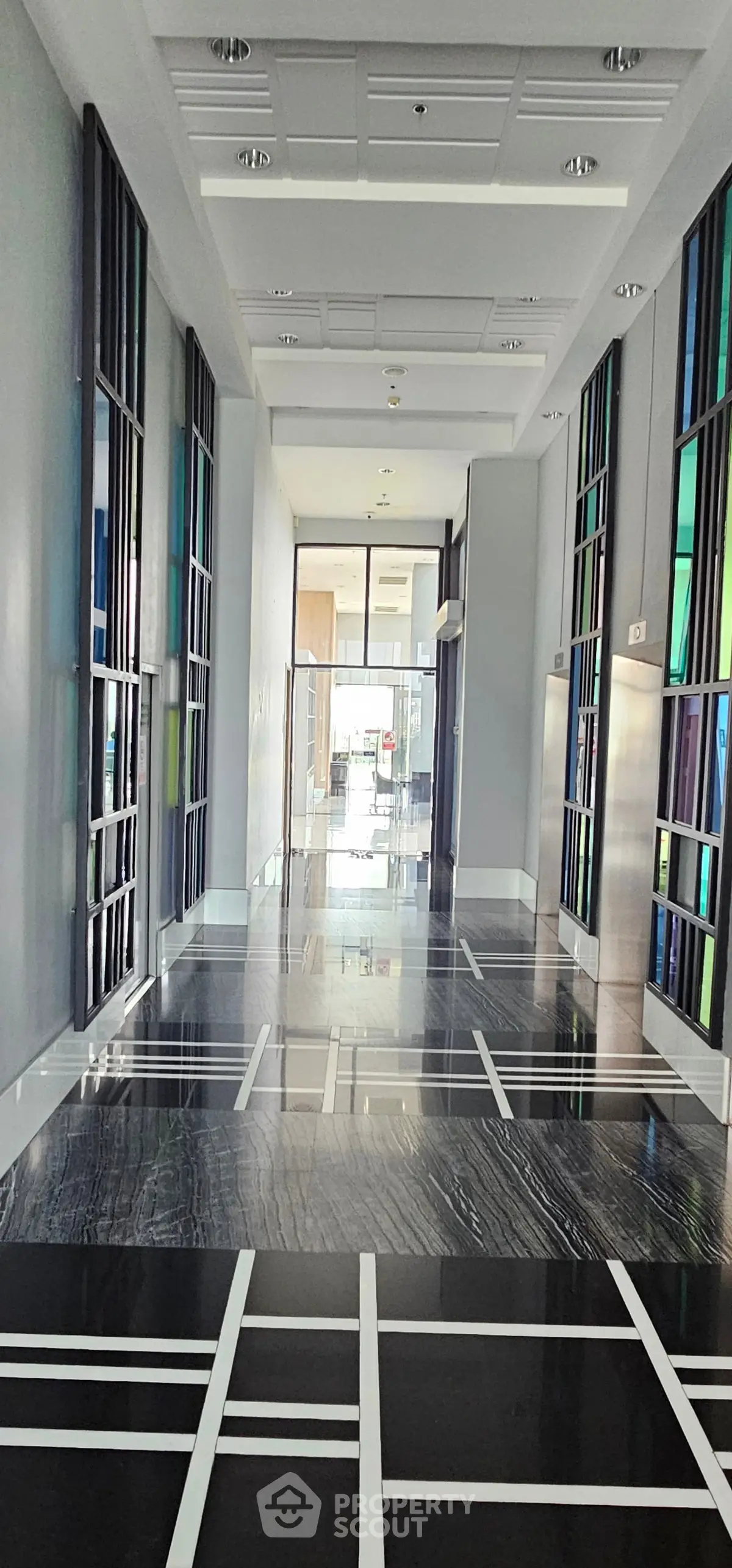 Modern building corridor with sleek black and white flooring and glass accents