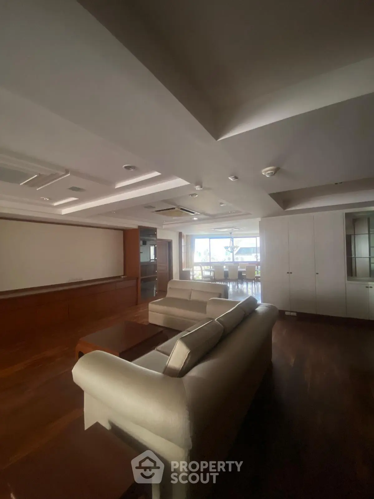 Spacious living room with elegant sofas and large windows offering natural light.