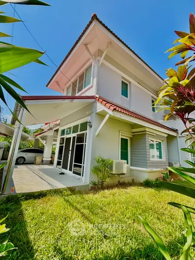 Charming two-story house with lush garden and carport in sunny setting
