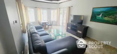 Spacious living room with modern furniture and large TV, perfect for relaxation and entertainment.