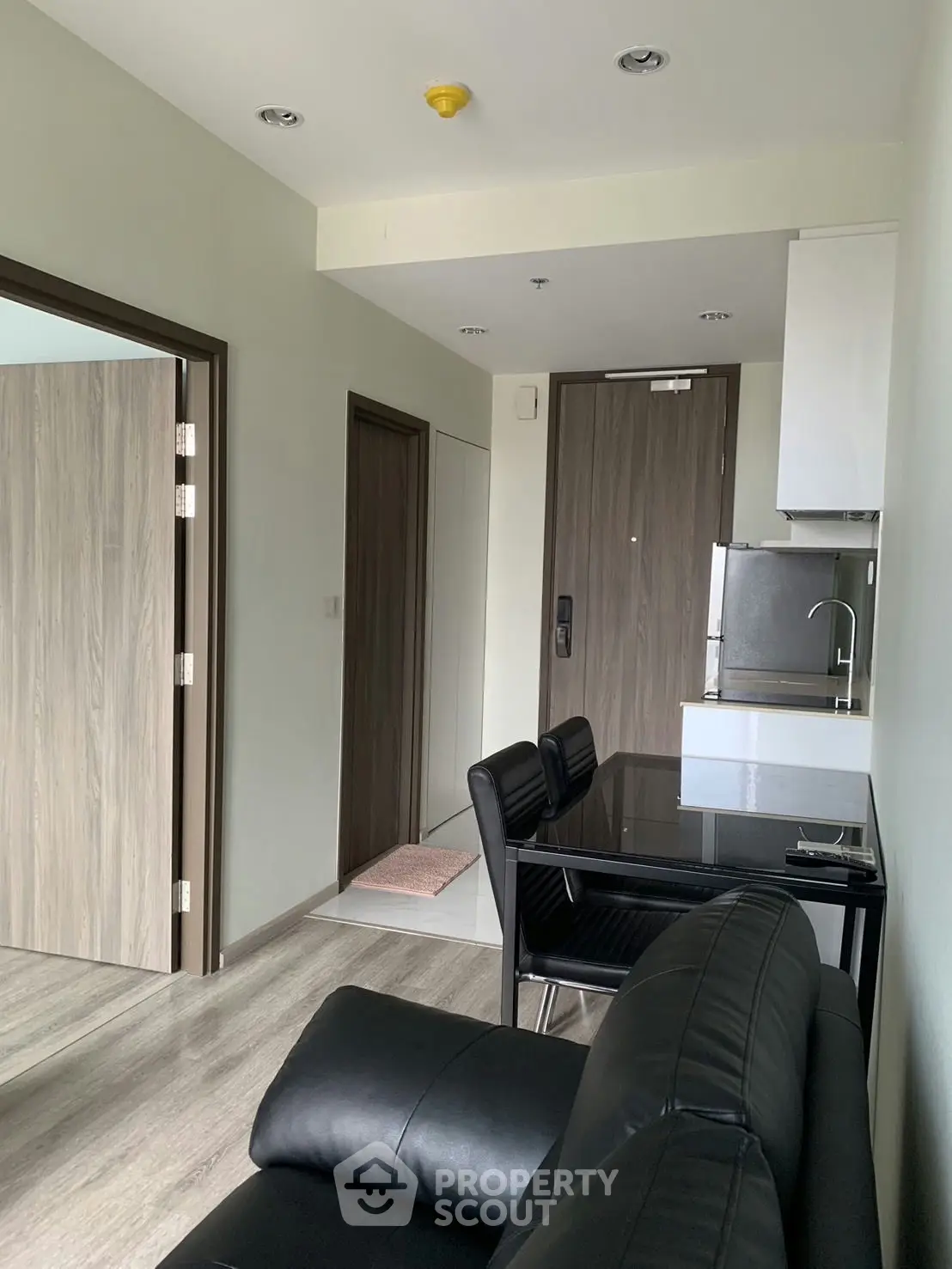 Modern apartment interior with sleek kitchen and cozy living area, featuring stylish furniture and contemporary design.