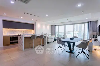 Luxurious open-plan living room with modern kitchen and stunning city view balcony.