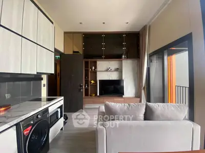 Modern living room with sleek kitchen and cozy sofa, featuring a stylish TV unit and large windows.