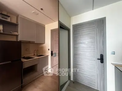 Modern compact kitchen with sleek cabinetry and integrated appliances in a stylish apartment.