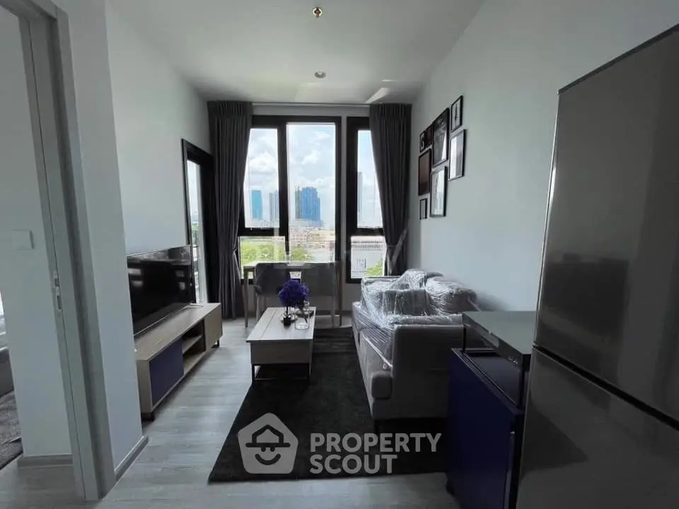 Modern living room with large windows and stylish decor in a high-rise apartment.