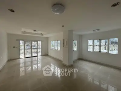 Spacious empty living room with large windows and natural light
