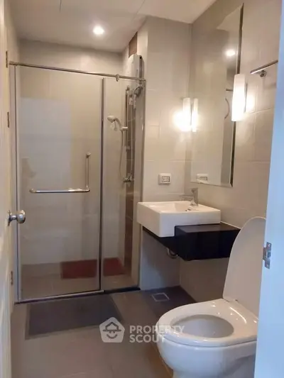 Modern bathroom with glass shower and sleek fixtures in a contemporary home.