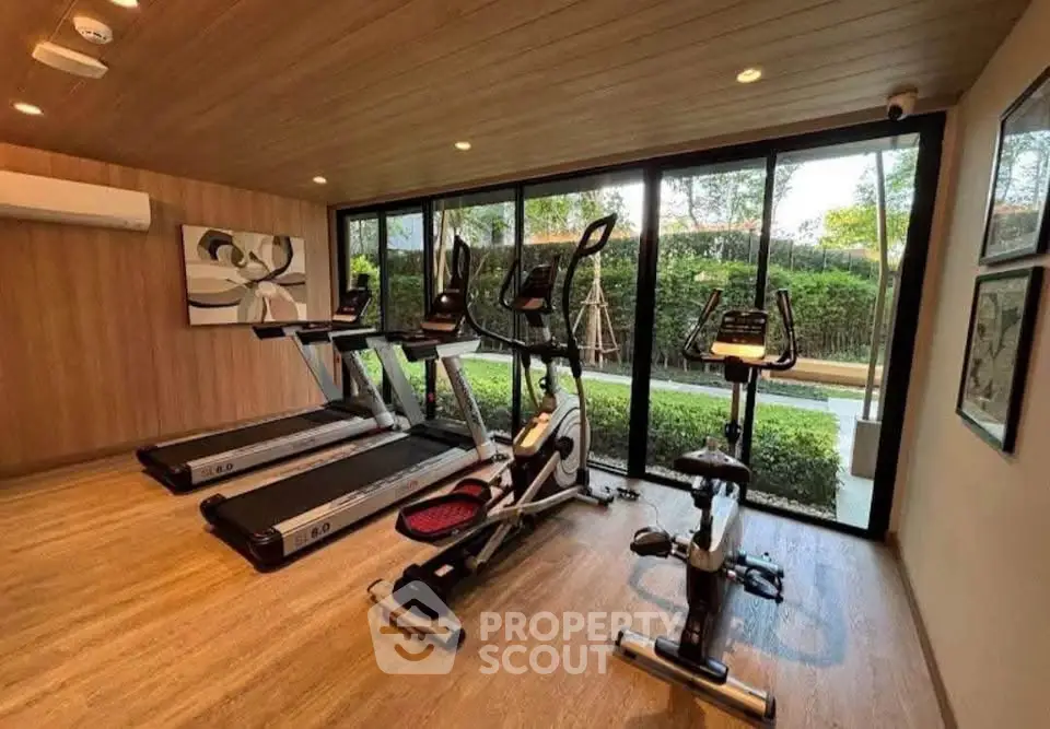 Modern gym with treadmills and exercise bike in a stylish residential building.