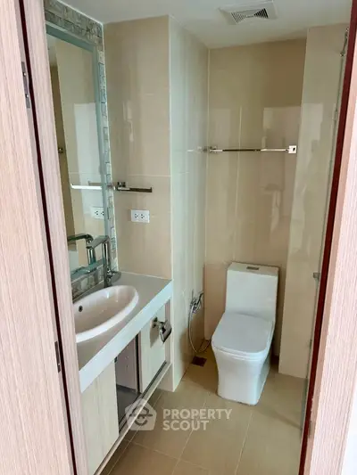 Modern bathroom with sleek fixtures and neutral tones, featuring a compact design for efficient space use.