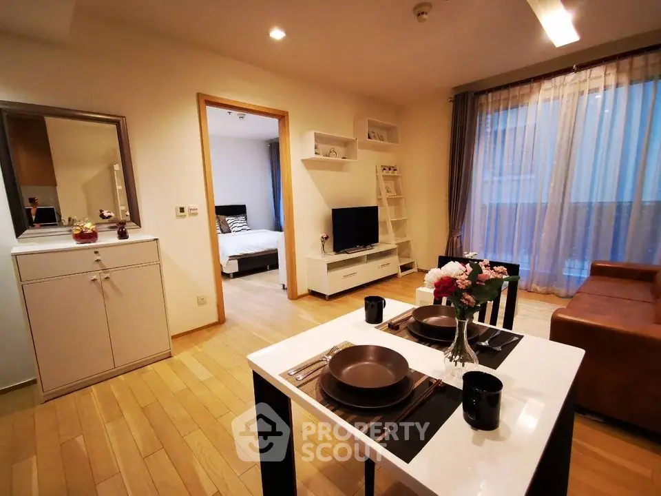 Modern open-plan living room with dining area and cozy bedroom view
