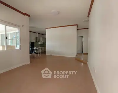 Spacious open-plan living area with modern kitchen and dining space, featuring sleek finishes and ample natural light.