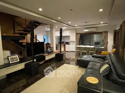 Luxurious open-plan living room with modern furnishings and elegant staircase