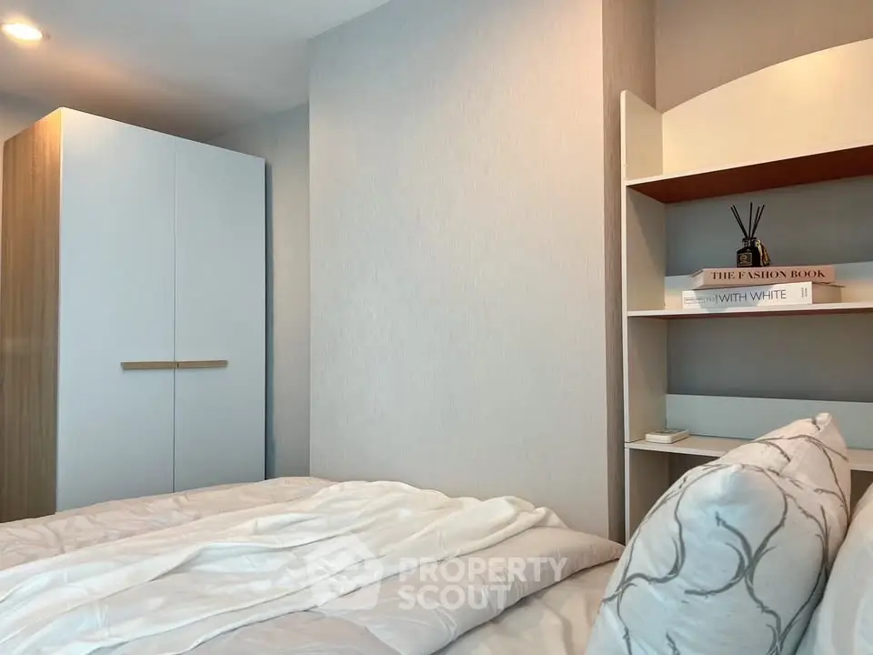 Cozy bedroom with modern wardrobe and stylish shelving, perfect for a serene living space.