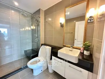 Modern bathroom with sleek design, glass shower, and elegant fixtures in a contemporary home.