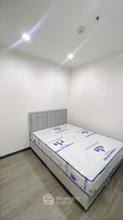 Modern minimalist bedroom with new mattress and sleek flooring