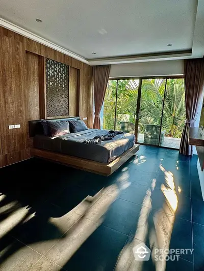 Luxurious bedroom with modern design and large windows overlooking lush greenery.