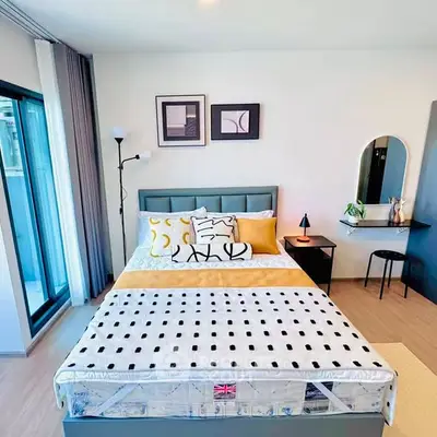 Modern bedroom with stylish decor and large window for natural light.