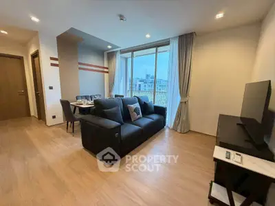 Modern living room with stylish decor and city view, featuring a cozy sofa and dining area.