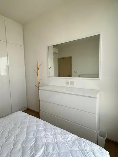Modern minimalist bedroom with white furniture and large mirror