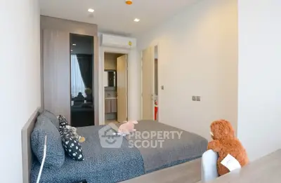 Cozy bedroom with modern decor and plush toys, featuring a stylish wardrobe and en-suite bathroom.