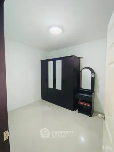 Spacious bedroom with sleek wardrobe and vanity set, perfect for modern living.
