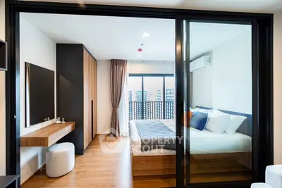 Modern bedroom with glass partition and stylish decor in a high-rise apartment.