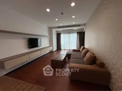Spacious living room with modern decor and large sofa in a stylish apartment.