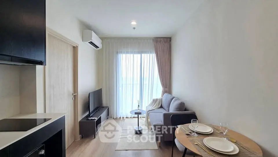Modern living room with cozy sofa, TV, and dining area in a bright apartment.