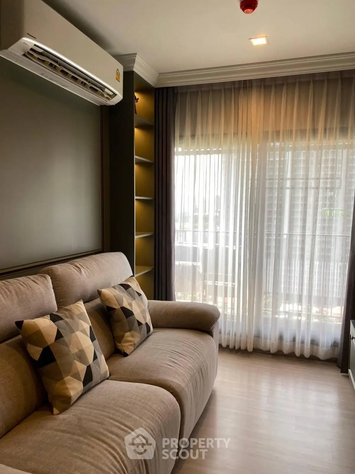 Modern living room with cozy sofa and large window with sheer curtains