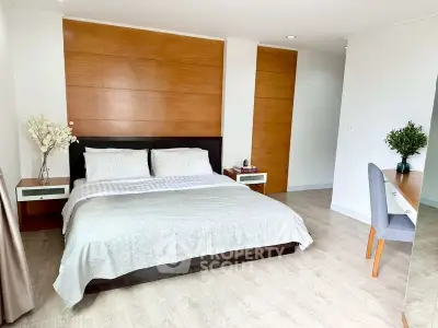 Spacious modern bedroom with elegant wooden accents and cozy ambiance.