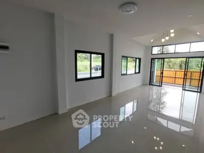Spacious modern living room with large windows and glossy tiled floor