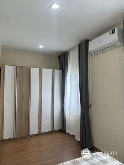 Modern bedroom with stylish wardrobe and air conditioning in a cozy apartment.