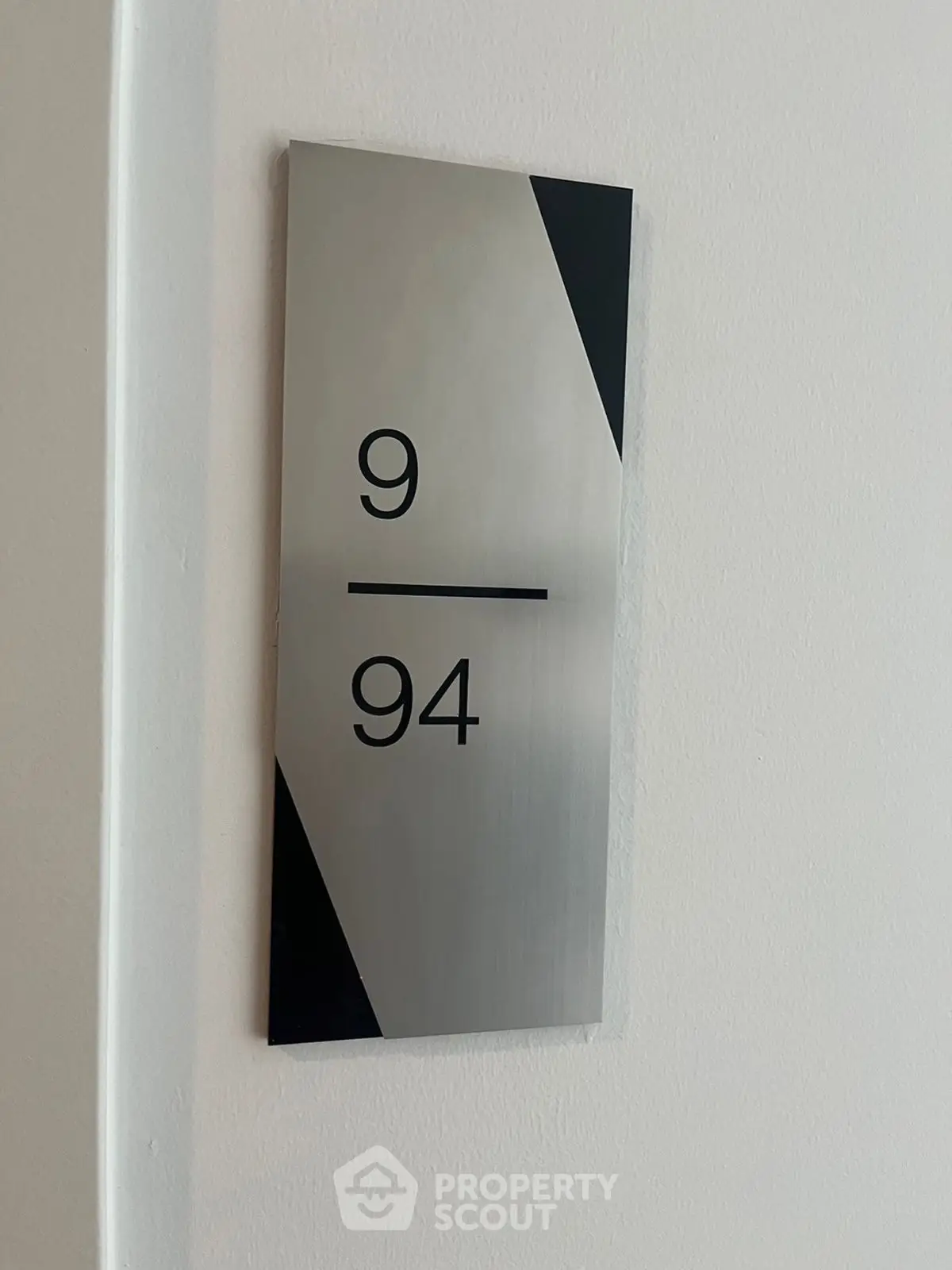 Modern apartment door number sign with sleek design and minimalist style.