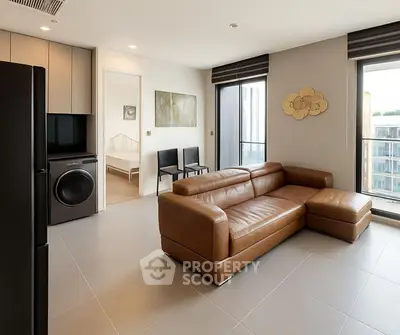Modern living room with leather sofa and open view, adjacent to bedroom and kitchen.