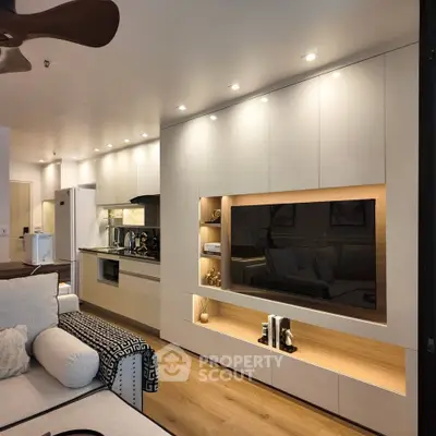 Modern living room with built-in entertainment center and open kitchen layout