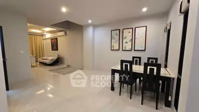 Spacious modern living and dining area with elegant decor and ample lighting.