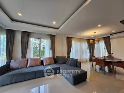 Spacious living room with modern furniture and elegant dining area, perfect for family gatherings.